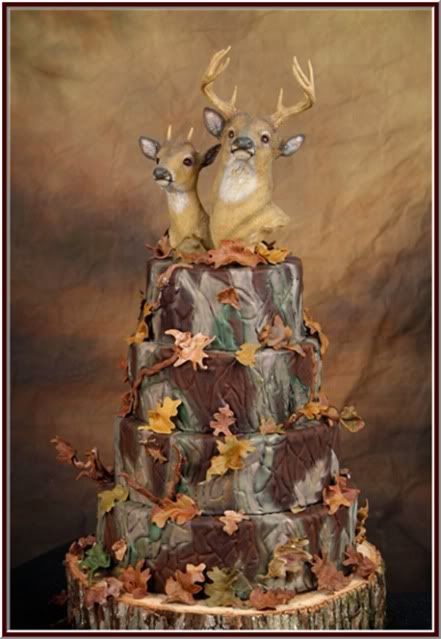 A picture of a multi-layered wedding cake decorated with a doe and buck on top of a tree trunk sprinkled with fall leaves! 