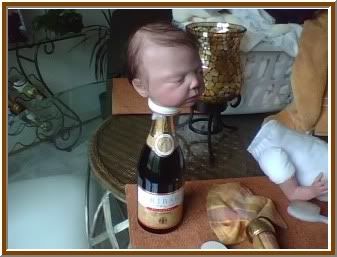 the head of a Reborn doll sitting on a bottle waiting for it's body to be restuffed